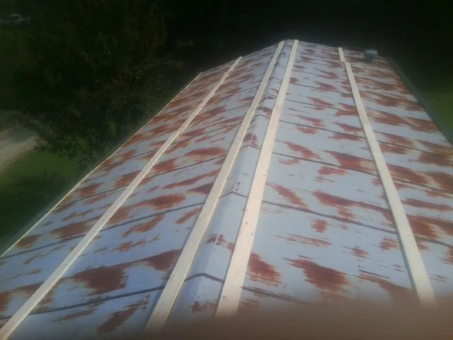Rusted metal roof panels with new wood purlins before replacement — Storm Damage Roof Repair in Knights Landing by Roofing Brothers