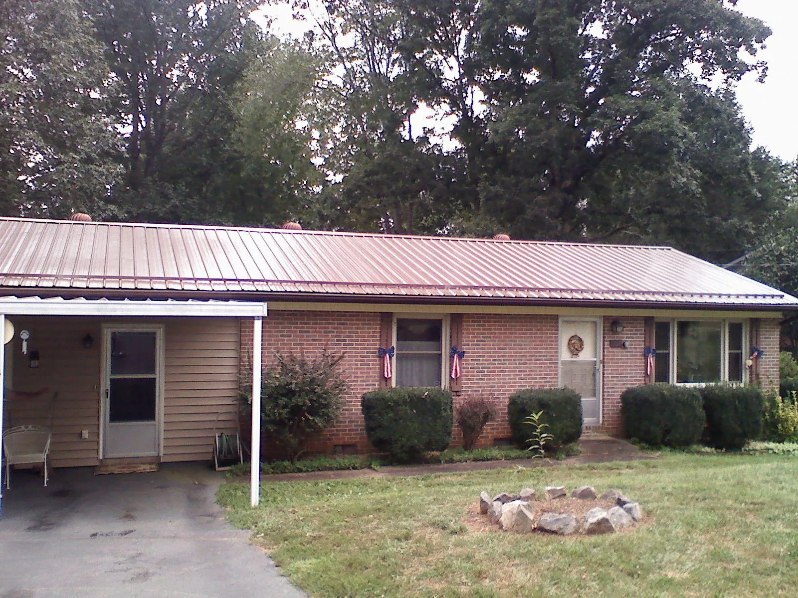 Bronze metal roof and carport on a brick ranch home — Roof Repair work by our crew in Knights Landing